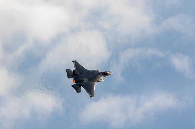 白い雲が浮かぶ青空を飛行する航空自衛隊の戦闘機F-35の写真