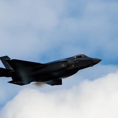 雲の合間を縫って飛行する航空自衛隊の戦闘機の写真