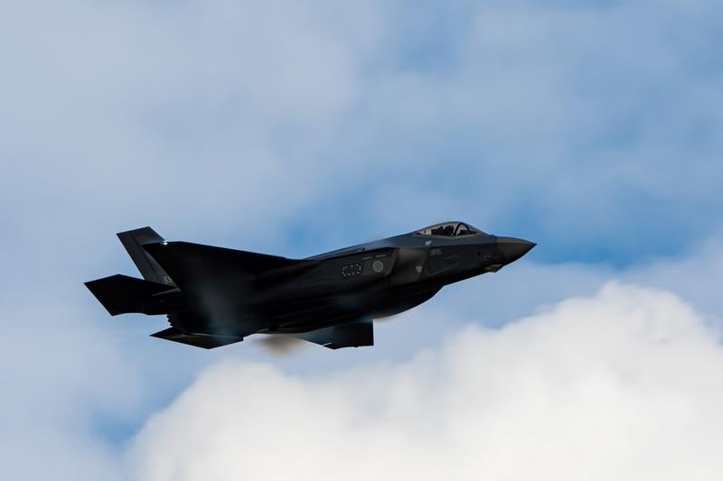雲の合間を縫って飛行する航空自衛隊の戦闘機の写真