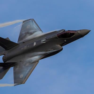 青空の中を飛行する航空自衛隊のF-35ライトニング戦闘機の写真