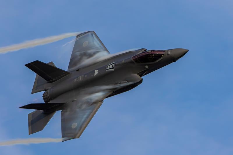 青空の中を飛行する航空自衛隊のF-35ライトニング戦闘機の写真