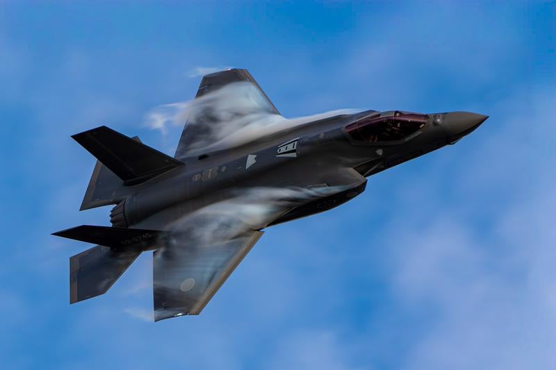 青空を背景に高速飛行するステルス戦闘機の写真