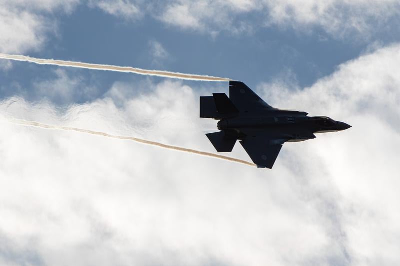 白い雲が浮かぶ空を飛行する航空自衛隊の戦闘機の写真