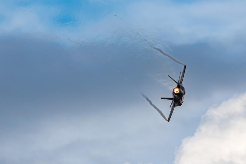 曇り空を背景に飛行する航空自衛隊の戦闘機の写真