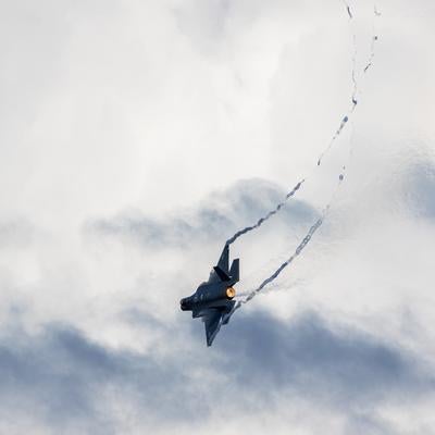 白い雲に包まれた空を飛行する航空自衛隊の戦闘機の写真