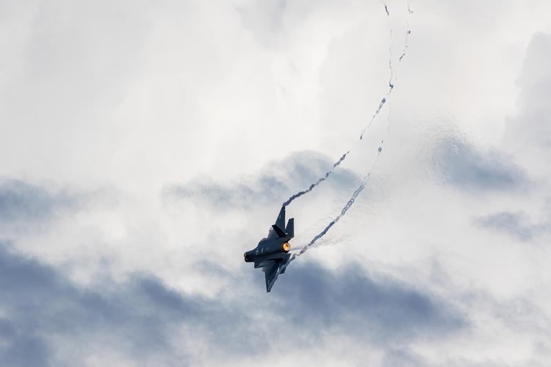 白い雲に包まれた空を飛行する航空自衛隊の戦闘機の写真