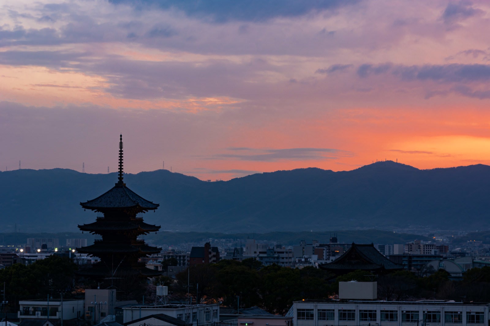 「薄く紅が残る空の下ライトアップの始まった東寺」の写真