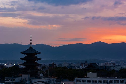 薄く紅が残る空の下ライトアップの始まった東寺の写真