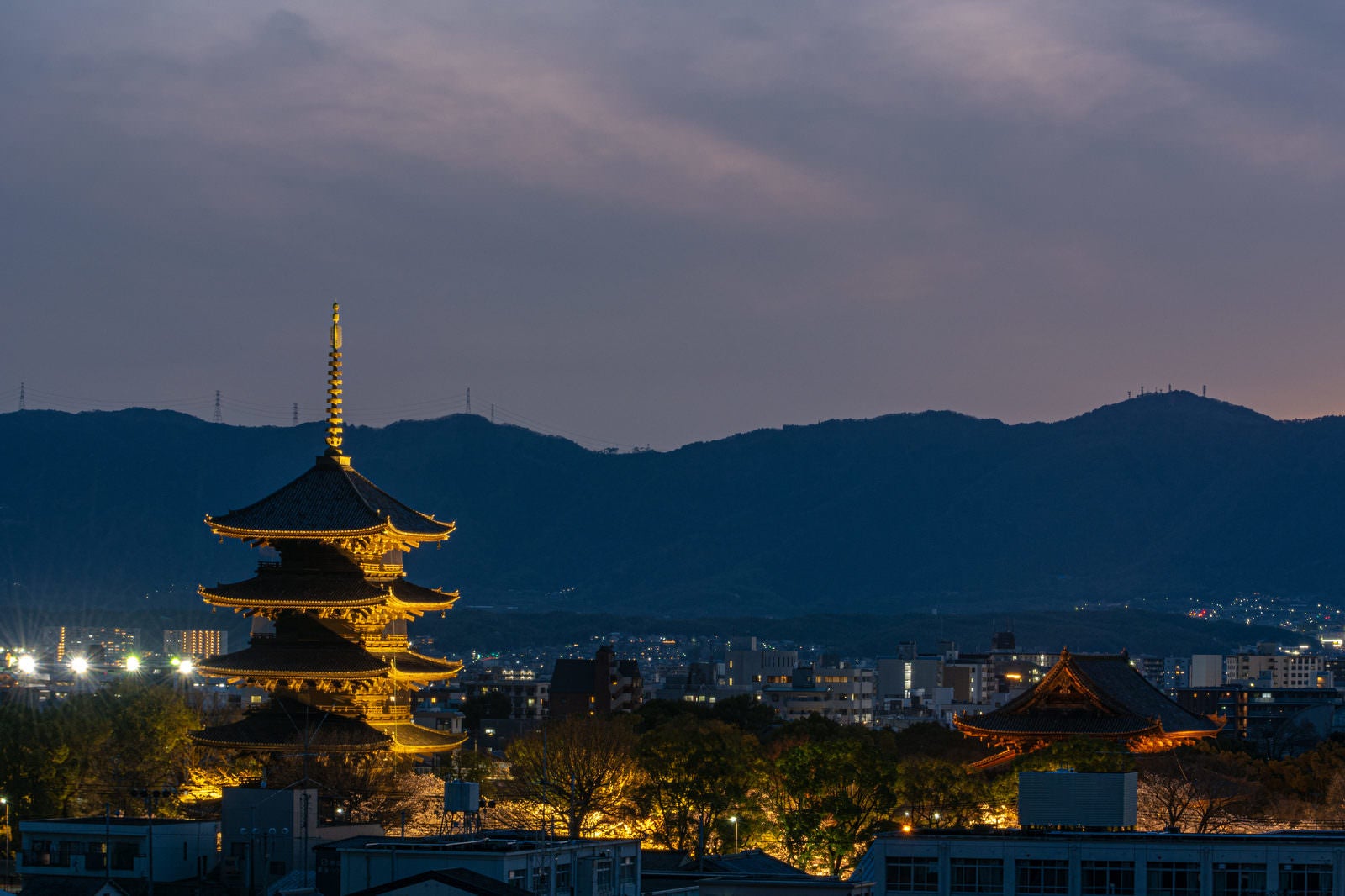 「夕暮れから夜へと変わる空の下ライトアップされた東寺五重塔」の写真