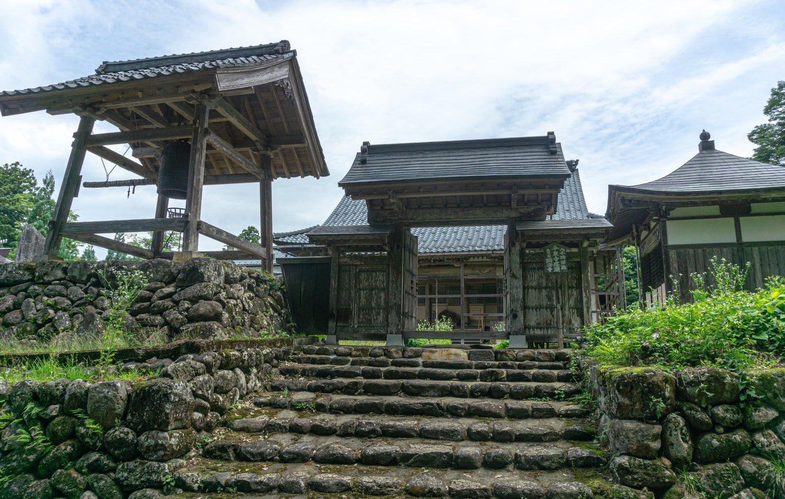 「精進坂手前の顕海寺の山門と立ち並ぶ建物」の写真