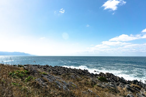 島の遊歩道から見える雄島の西側に広がる板状節理に打ち寄せる波の写真