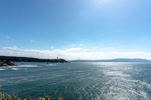 雄島の大湊神社の海に向かって建つ鳥居の付近から見る眼下に広がる海と東尋坊や遠く霞む山々の写真