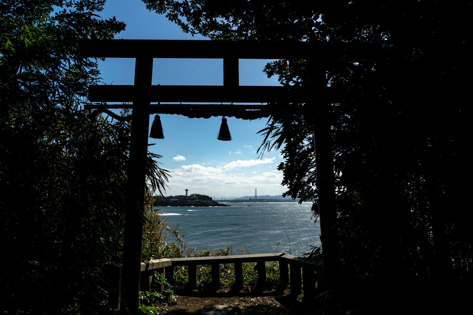 「大湊神社の海に向かって建つ鳥居の中に見える東尋坊方面」の写真