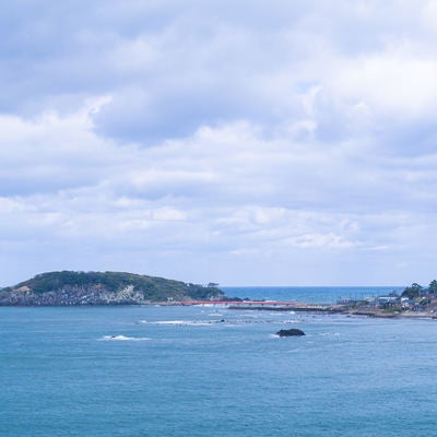東尋坊から見える海の神様の島と崇められる雄島と青い海にかかる赤い橋の写真