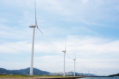 海沿いの風力発電用風車の写真