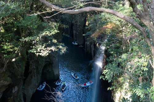 峡谷を楽しむ多くのボート（宮崎県高千穂町・真名井の滝）の写真