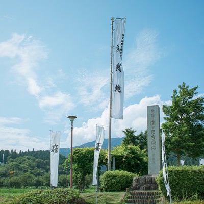 関ケ原決戦地の石碑とその左奥に見える石田三成陣跡の展望デッキの旗印とノボリの写真