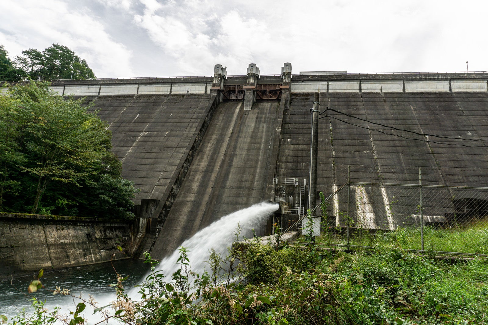 「河川維持の為に常時勢いよく水を放流する黒田ダムを近くから仰ぎ見る」の写真