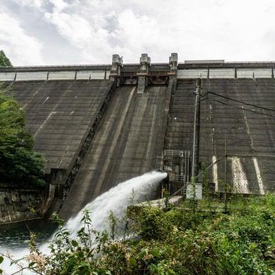 河川維持の為に常時勢いよく水を放流する黒田ダムを近くから仰ぎ見るの写真