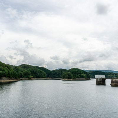 厚い雲に覆われた空の下に広がる黒田ダムによって作られた黒田湖の写真