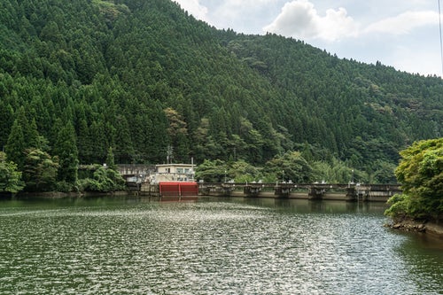 ダム湖側から見た矢作第二ダムと赤が目立つ矢作第二発電所への取水口の写真