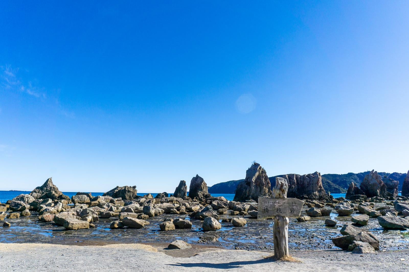 「海岸に並ぶ奇岩とその背後に広がる山並み」の写真
