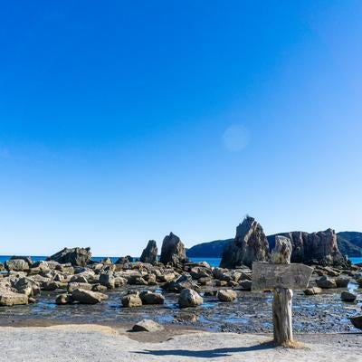 海岸に並ぶ奇岩とその背後に広がる山並みの写真