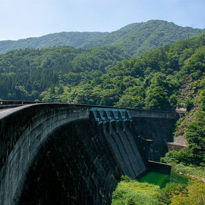 右岸から見る日本に11基しか存在しない重力式アーチダムの鷲ダムの姿の写真