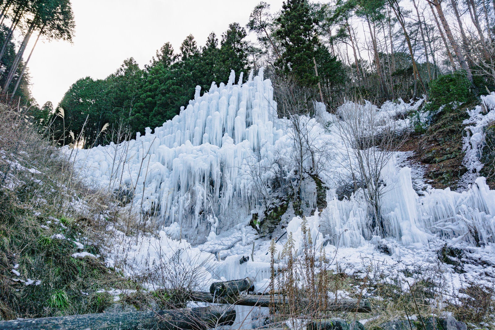 「組み上げられた丸太に水をかけて作られた湧水公園の氷瀑」の写真
