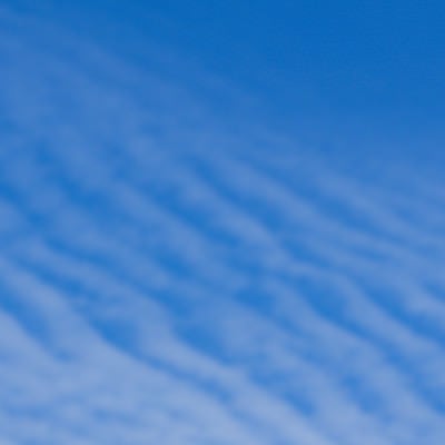青空に薄い波のように広がる巻積雲の写真