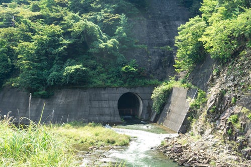 ダム下流側の青土ダム公園から見える下流への放水口の薄暗いトンネルの写真