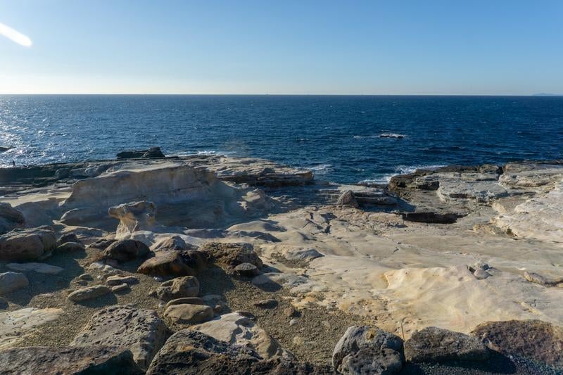 Vast Flat Rock Formations and Deep Blue Sea Along the Coastline