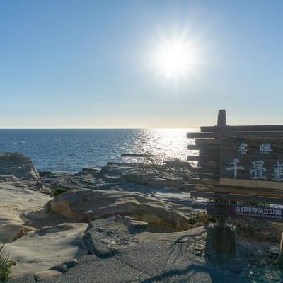 光に照らされる千畳敷と広大な海原の写真