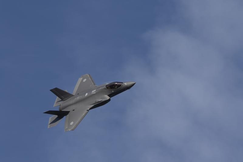 雲が浮かぶ青空を飛行する自衛隊のF-35A戦闘機の写真