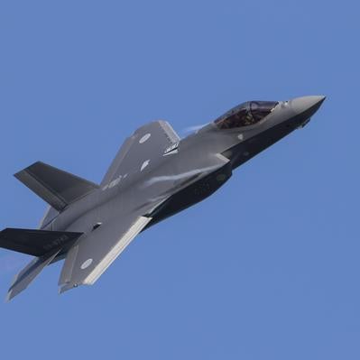 小松基地上空の青空にABの炎を引き機動飛行を披露するF35の写真