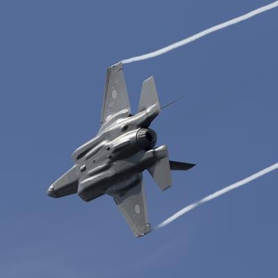 青空と白い雲を背景に飛行する航空自衛隊のF-35A戦闘機の写真