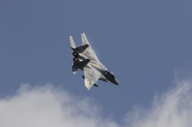 雲が浮かぶ青空を背景に飛行するF35A戦闘機の写真