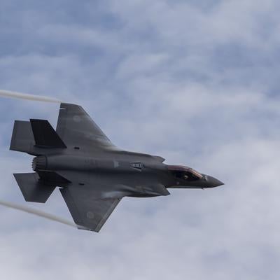 雲が広がる小松基地上空をF35戦闘機が翼の上や翼端からベイパーを発生させて機動飛行を行うの写真