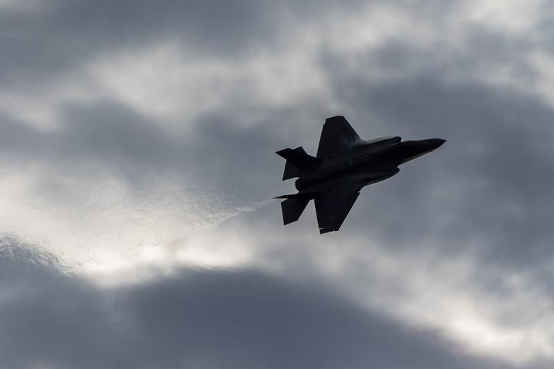黒雲を背景にしたジェットブラストが目立つF35のフライトの写真