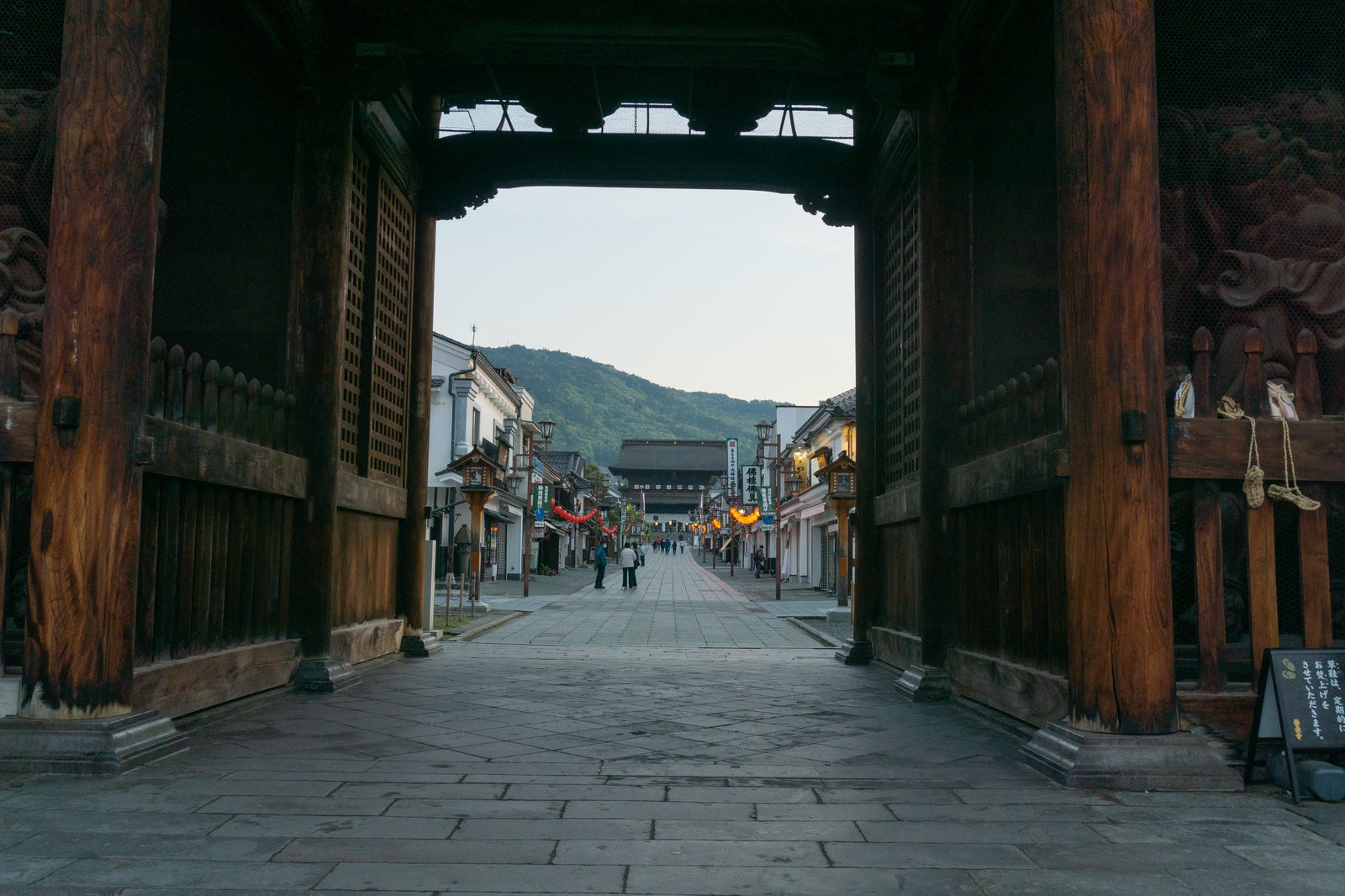 「仁王門越しに見える早朝の仲見世通りと奥に見える山門」の写真