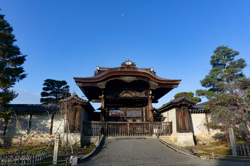 頭上に小さな朝の月を頂いた仁和寺の勅使門の写真