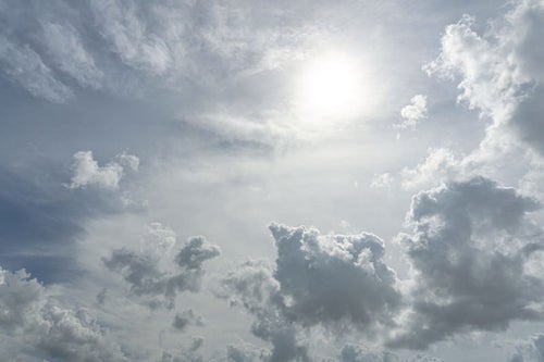空を覆う雲に隠れた太陽の写真